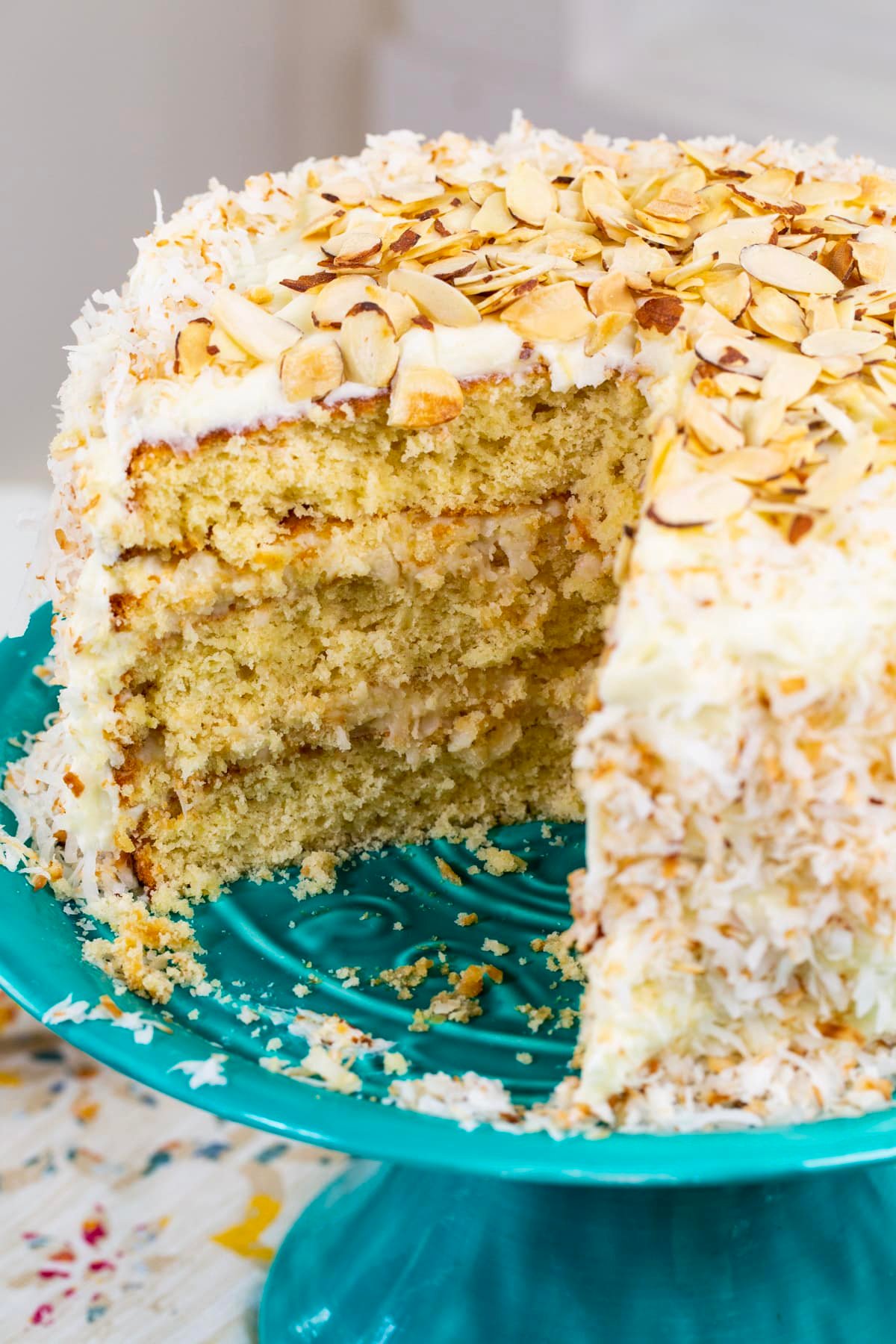 Coconut Almond Cream Cake with slice cut out.
