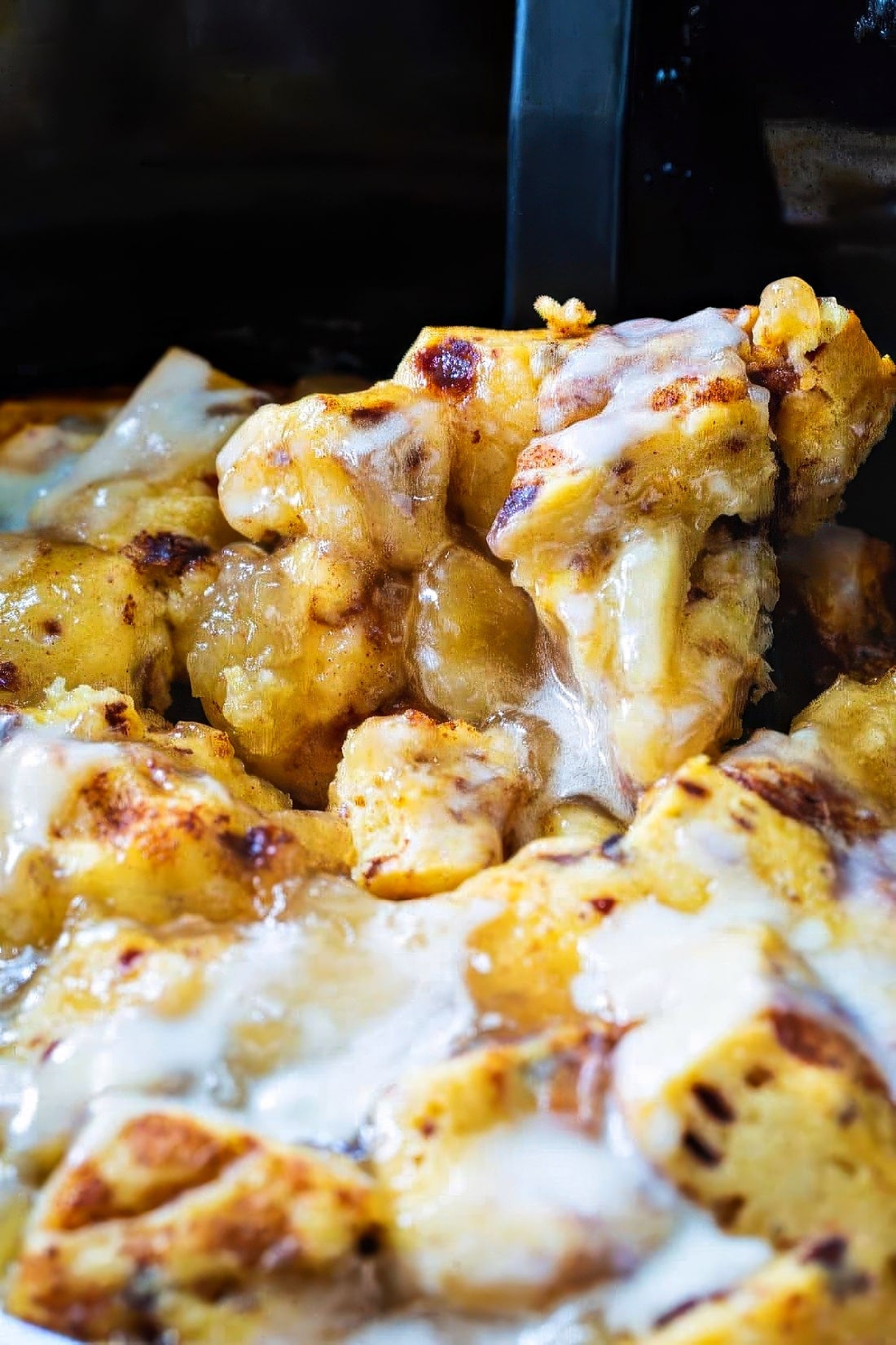 Spoon scooping up Apple Pie Cinnamon Roll Casserole.