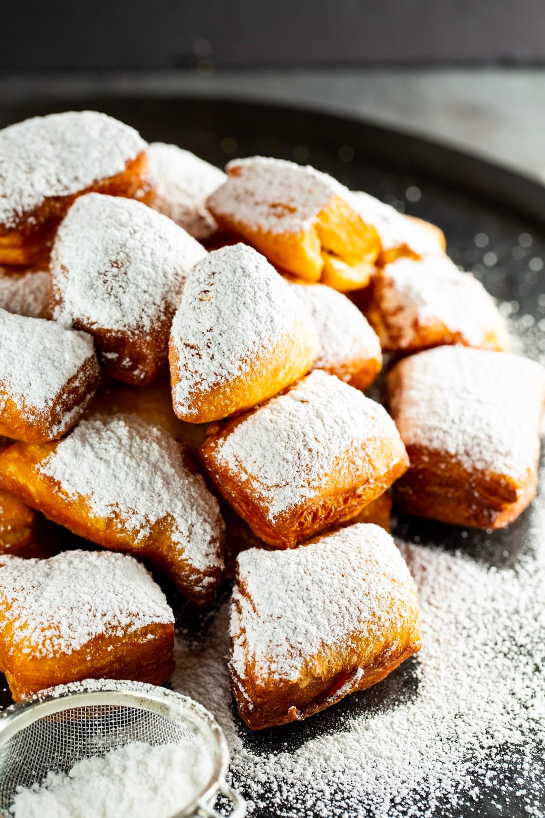 Beignets piled up on a serving tray.
