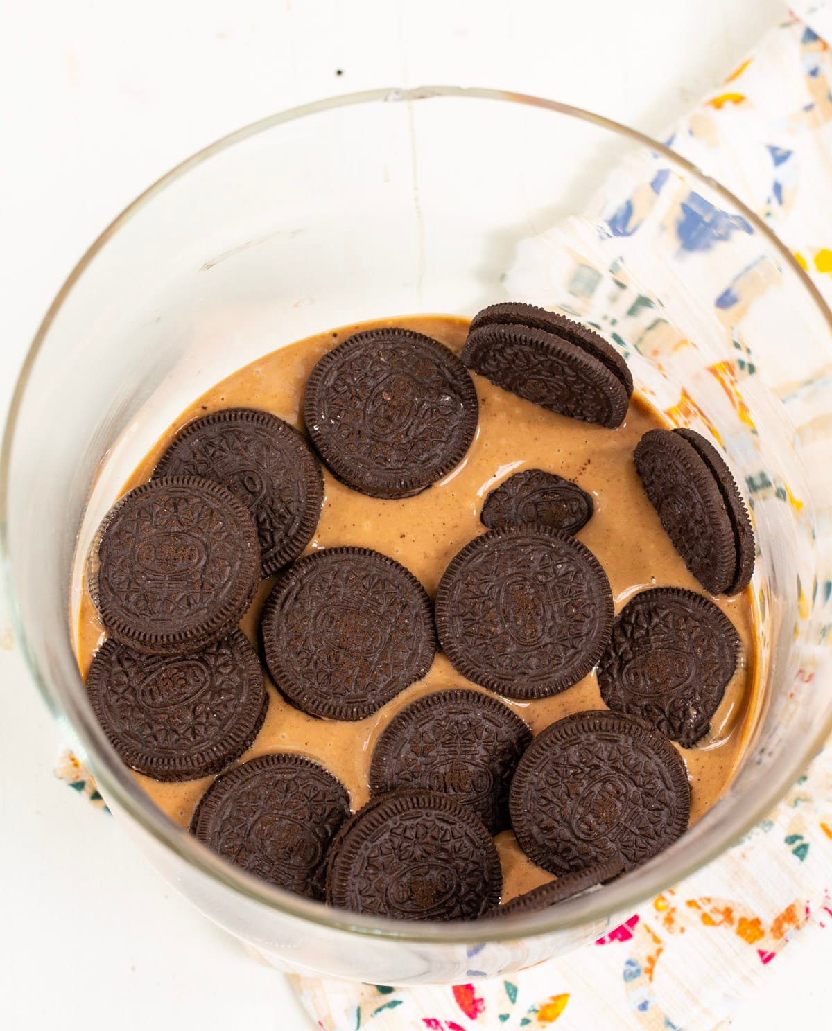 Oreos placed on top of pudding in trifle bowl.