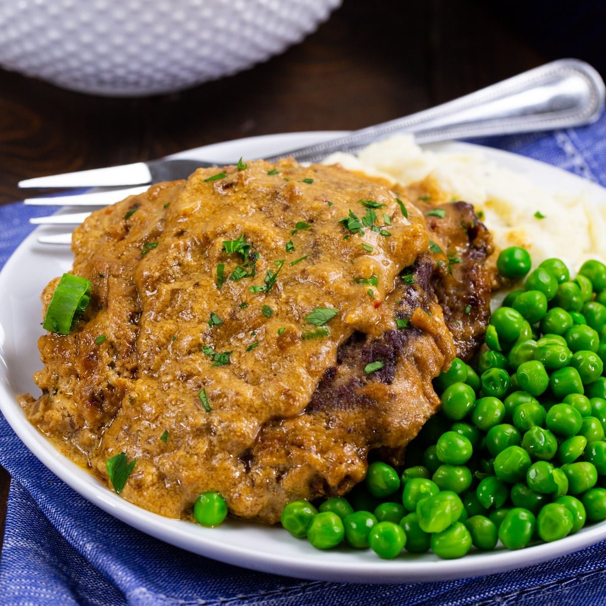 Sour Cream Cubed Beef on plate with mashed potatoes and peas.