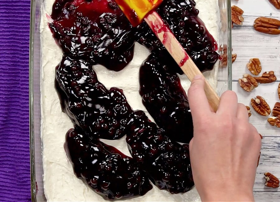 Spreading blueberry pie filling.