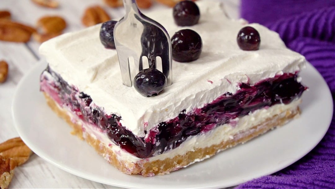 Fork going into piece of blueberry delight.