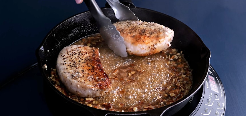 Returning the pork chops to skillet.