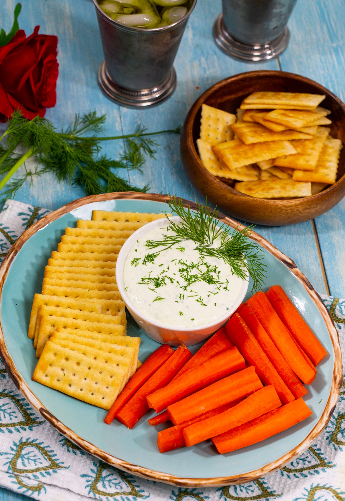 Benedictine dip in a bowl with crackers and carrot sticks.