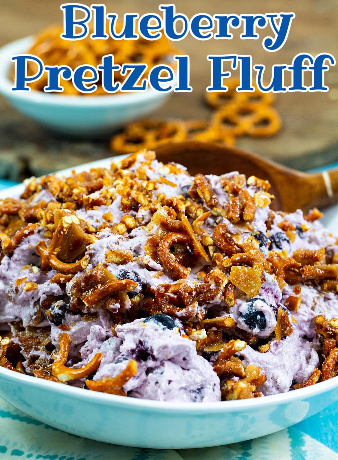 Spoon scooping blueberry pretzel fluff.