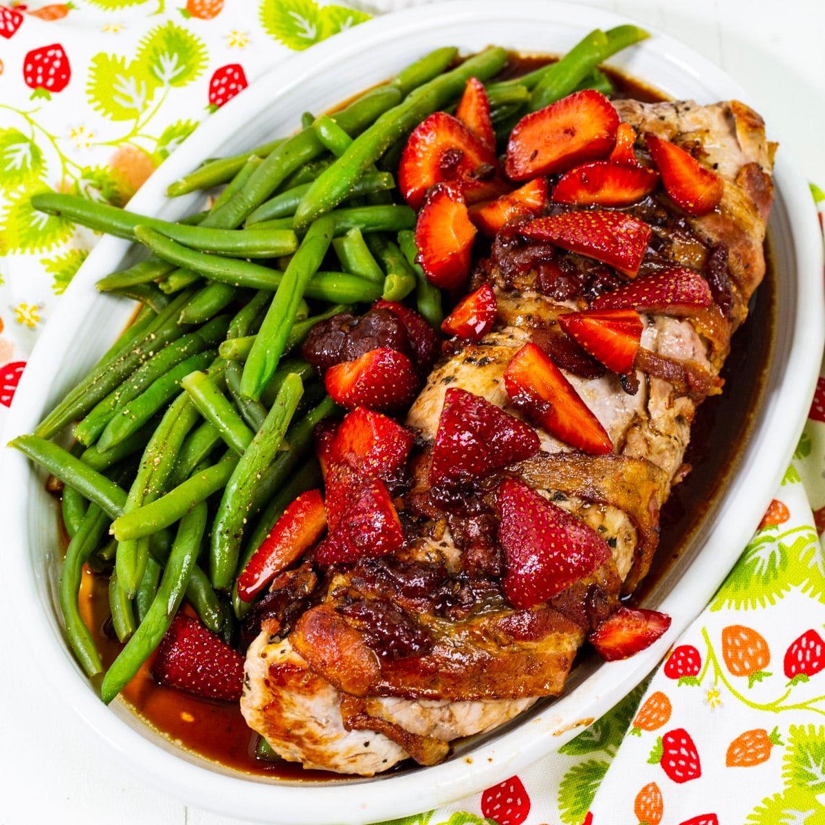 Pork Tenderloin with Balsamic Starwberries on a serving plate with green beans.