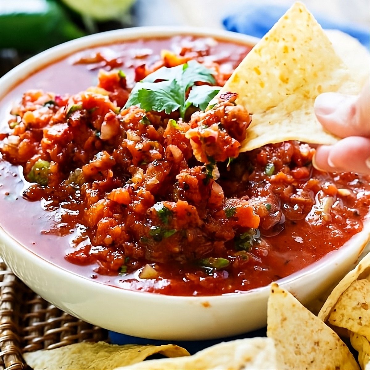 Chip dipping into fire-roasted salsa.