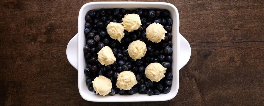 Dough place on top of blueberries.