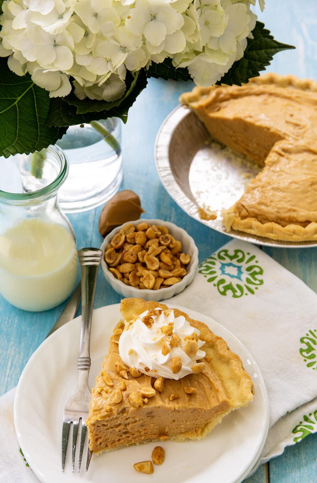 Slice of pie and bowl of peanuts.