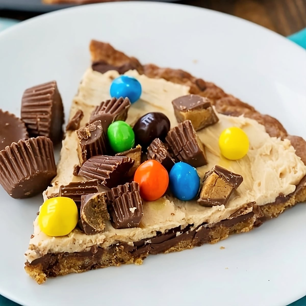 Slice of Peanut Butter Cup Dessert Pizza on a plate.