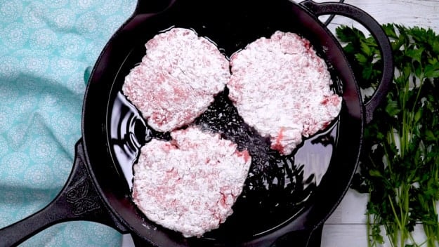 Cooking cubed steak in oil.