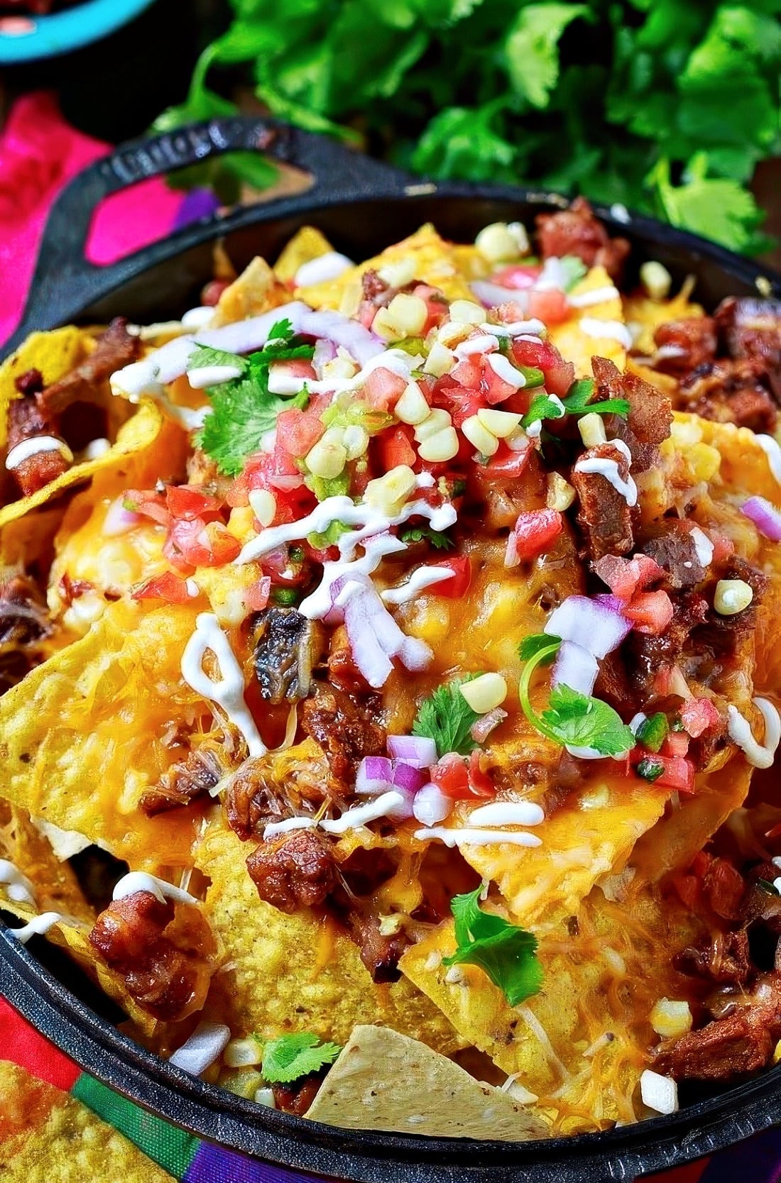 BBQ Brisket Nachos piled high in a cast iron skillet.