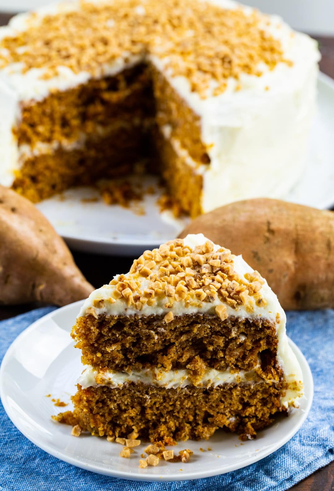 Slice of cake with cream cheese frosting on a plate.