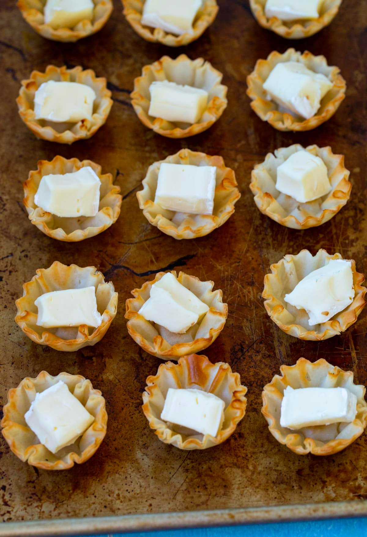 Phyllo shells with cubes of brie in them.