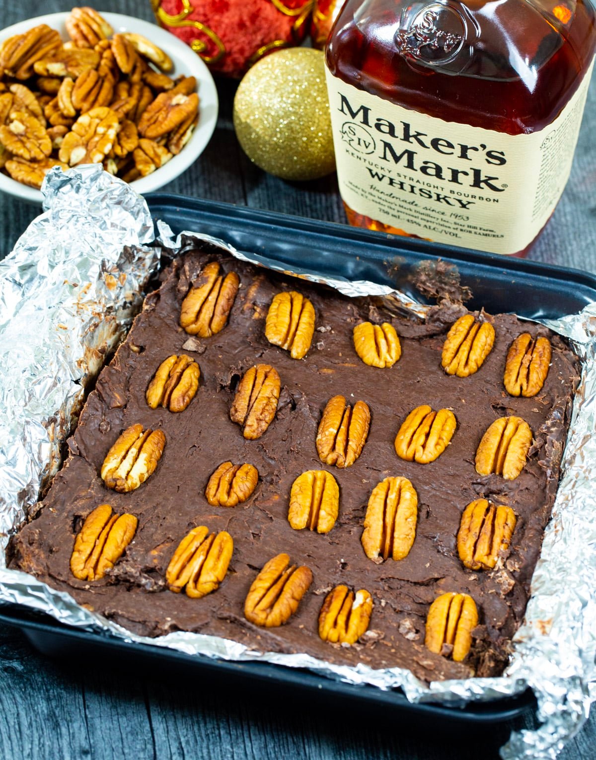 Bourbon Pecan Fudge in baking pan and a bottle of bourbon.