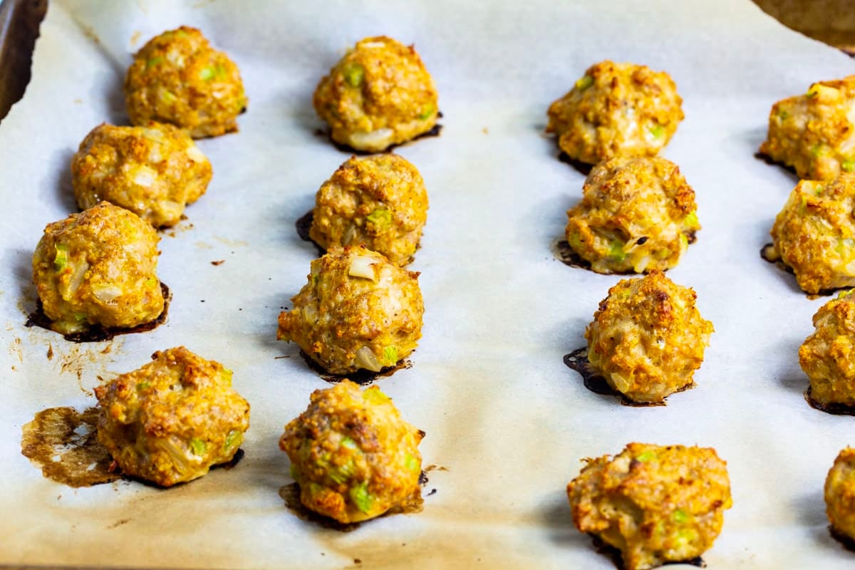 Baked meatballs on baking sheet.