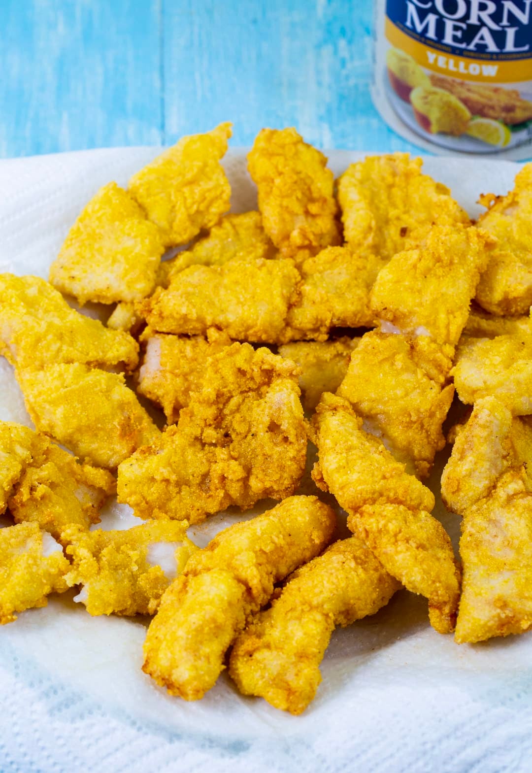Fried catfish pieces on paper towel-lined plate.
