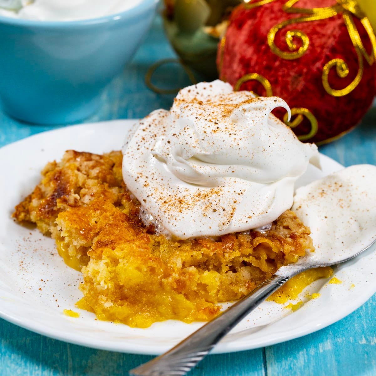 Piece of 3-Ingredient Eggnog Dump Cake topped with whipped cream.