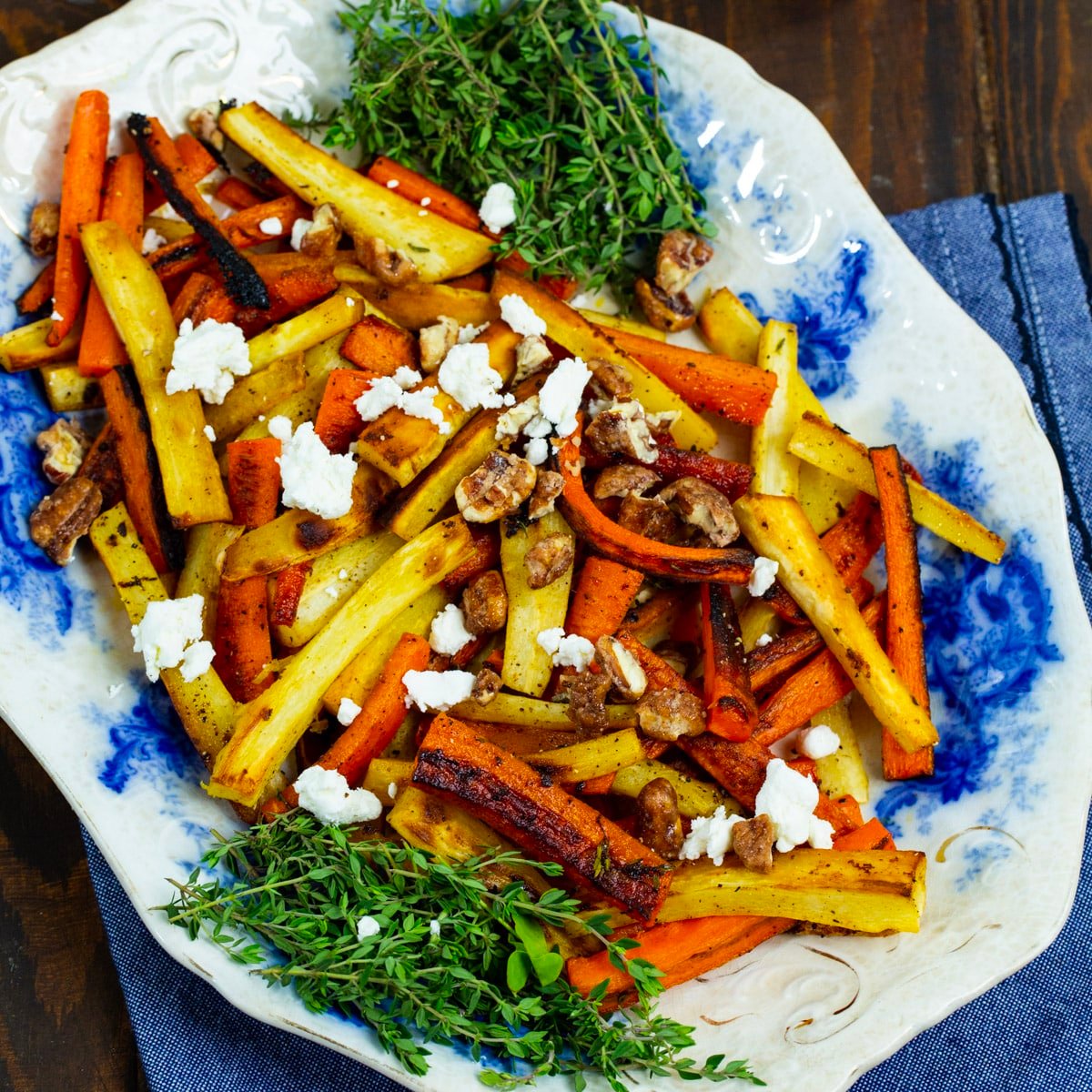 Roasted Carrots and Parsnips with Candied Pecans and Goat Cheese on a serving plate.