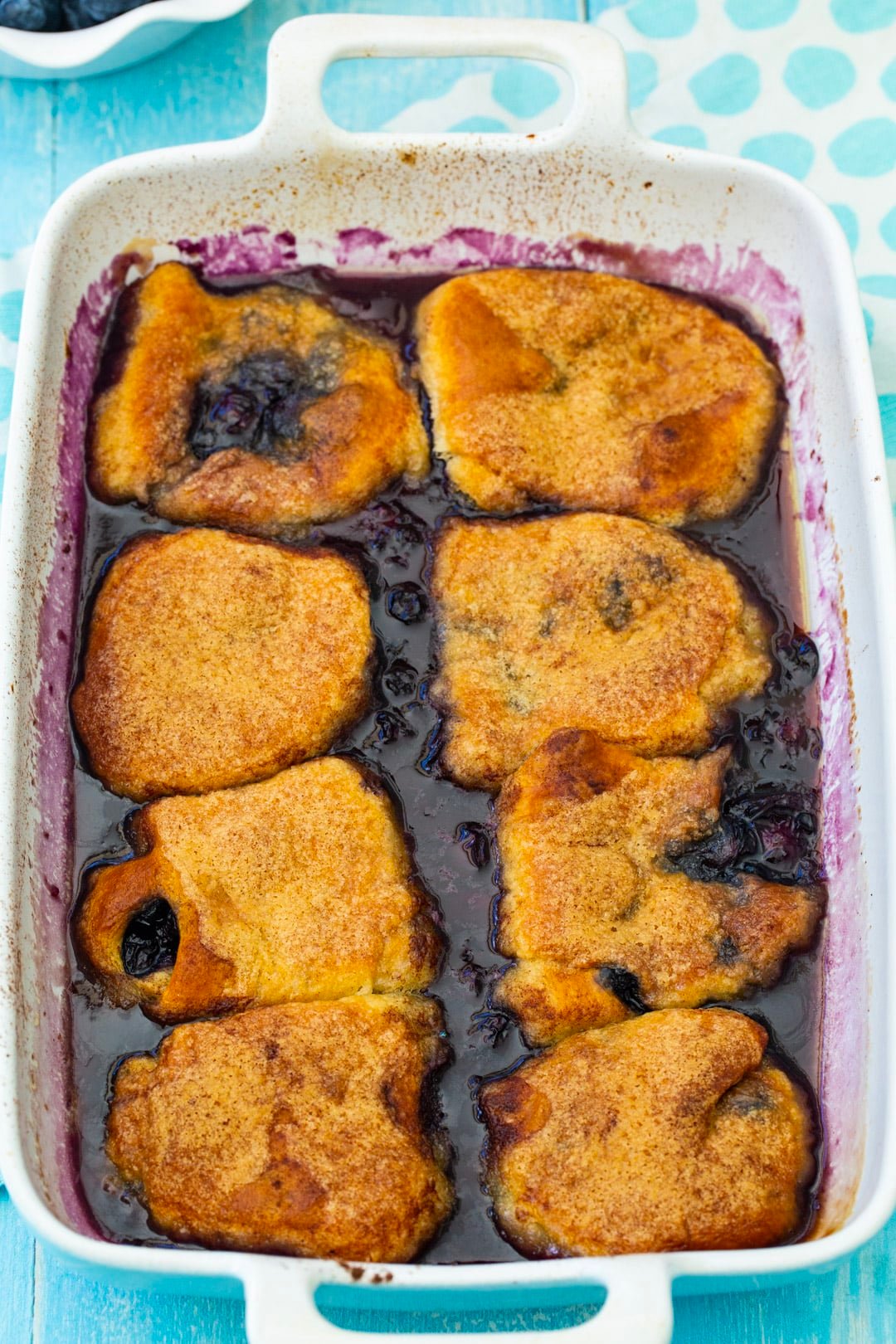 Dumplings with blueberries in a baking dish.