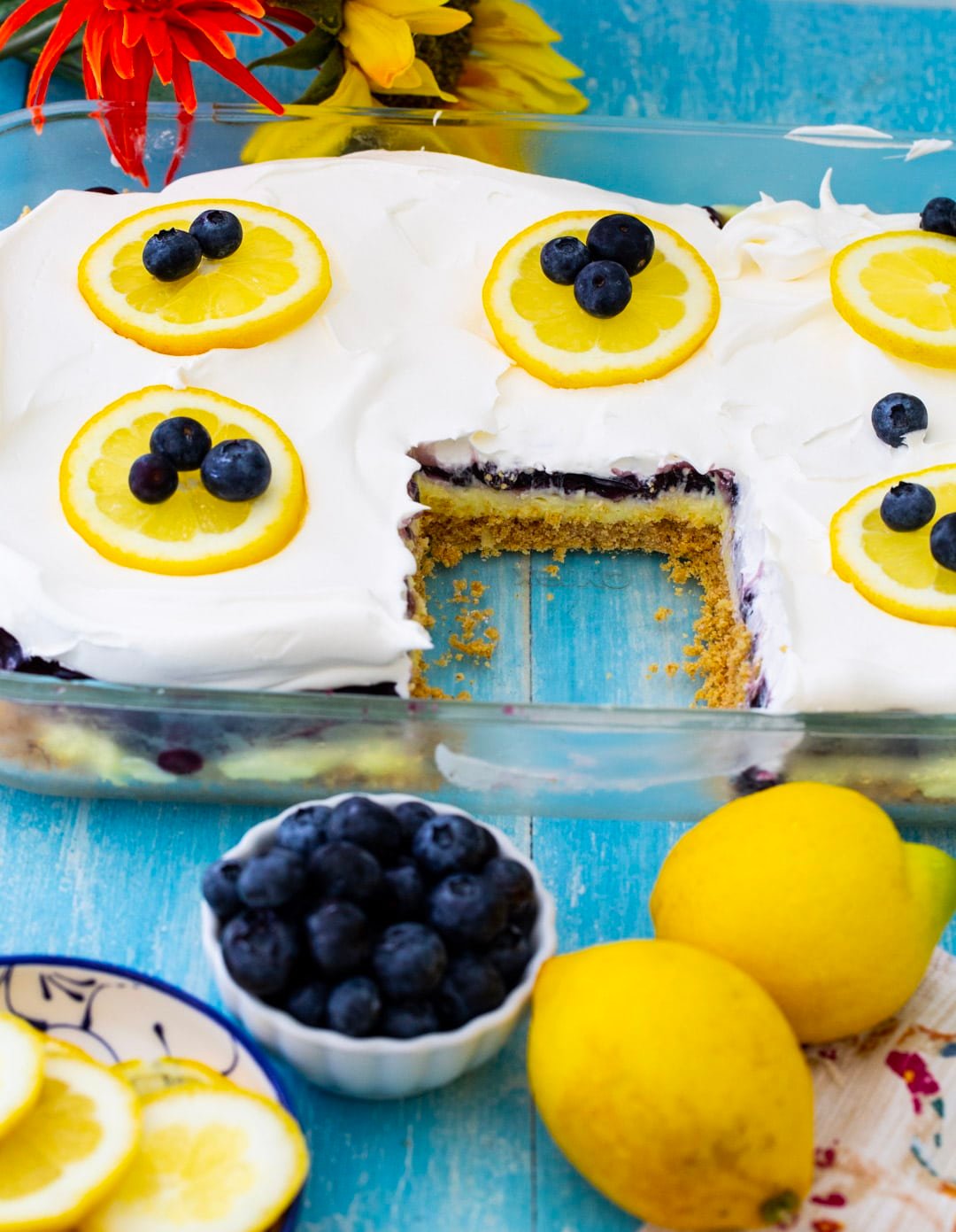 Blueberry Lemon Layer Dessert in baking dish with slice removed.