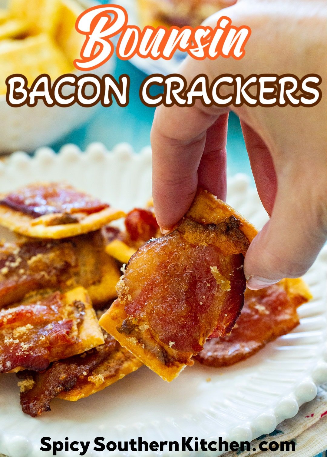 Hand picking up Boursin Bacon Cracker.