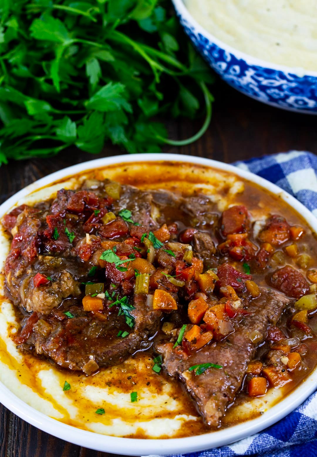 Slow Cooker Grillades served over grits.