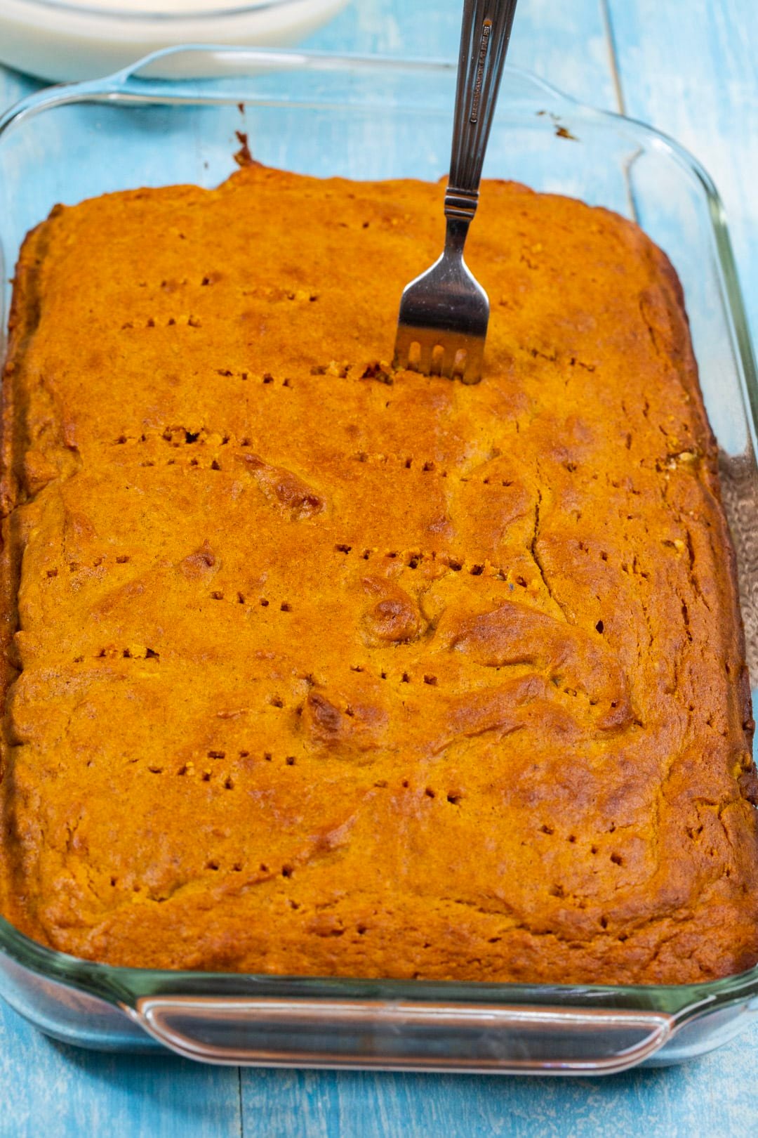 Poking holes in cake.