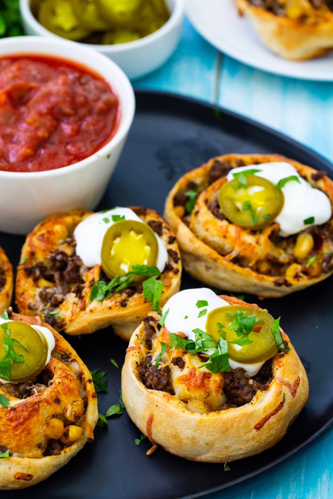 Taco Pizza Rolls topped with sour cream and cilantro.