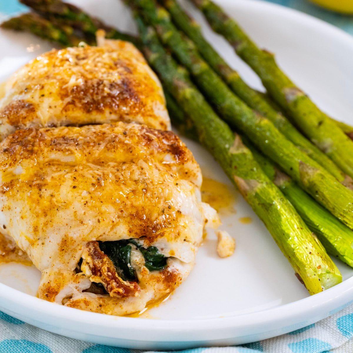 Spinach Stuffed Flounder on a plate with asparagus.