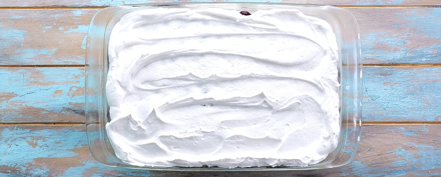 Spreading Cool Whip on top.