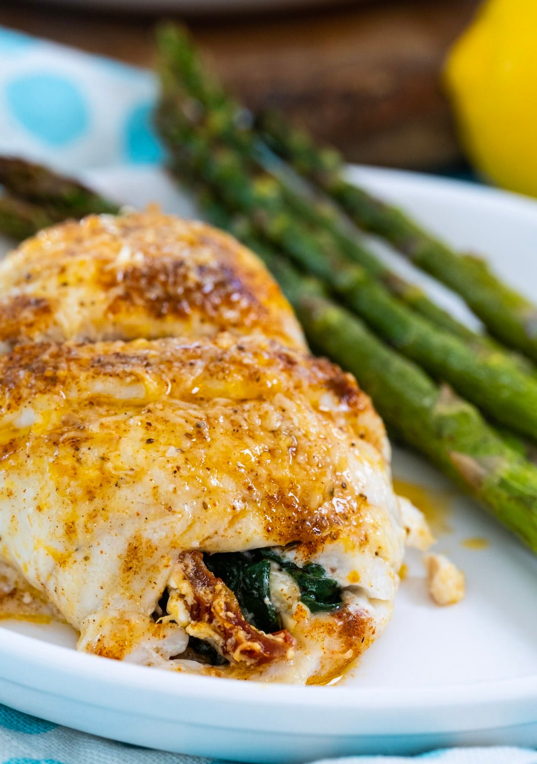 Stuffed Flounder with spinach on a plate with asparagus.