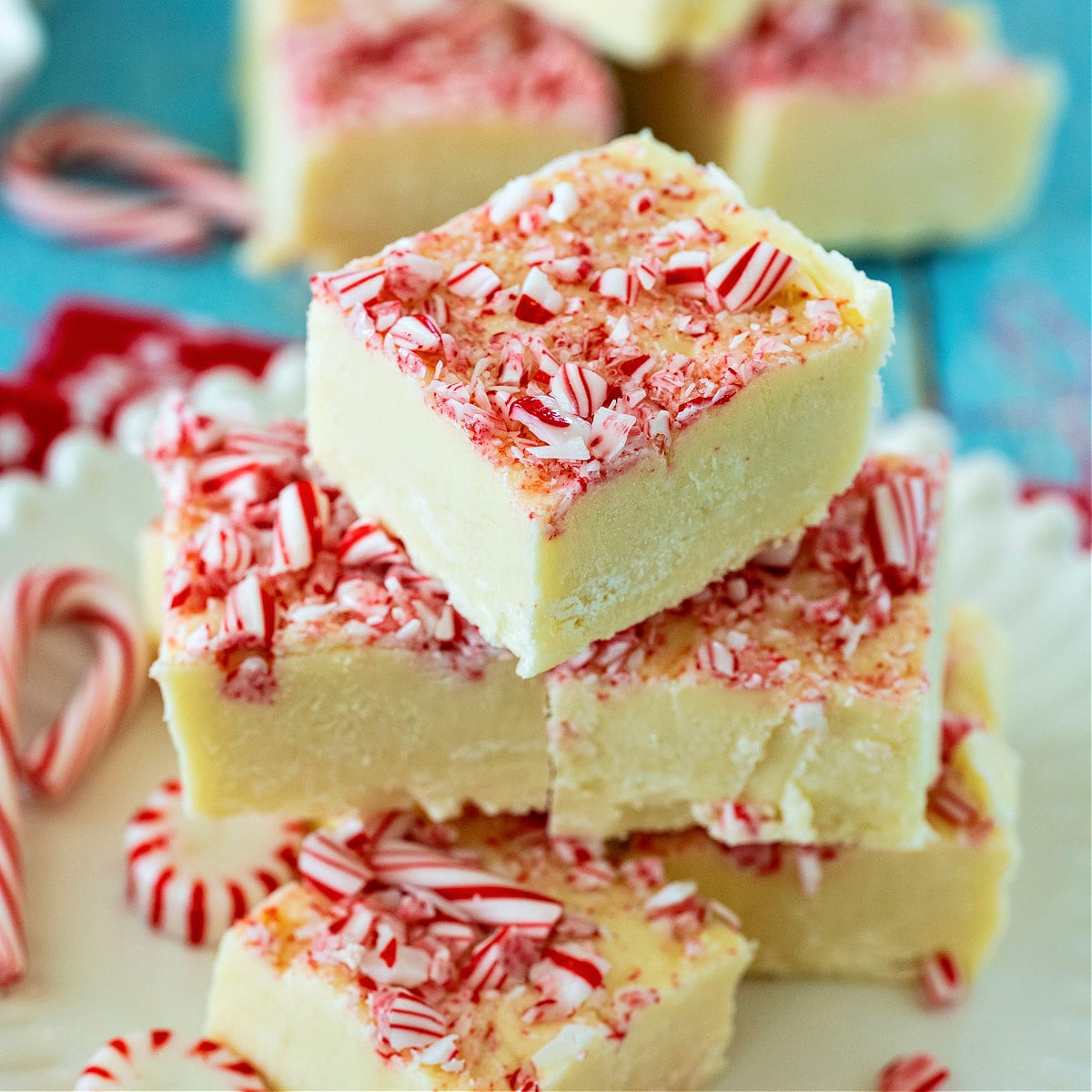Peppermint White Chocolate Fudge stacked up on a plate.