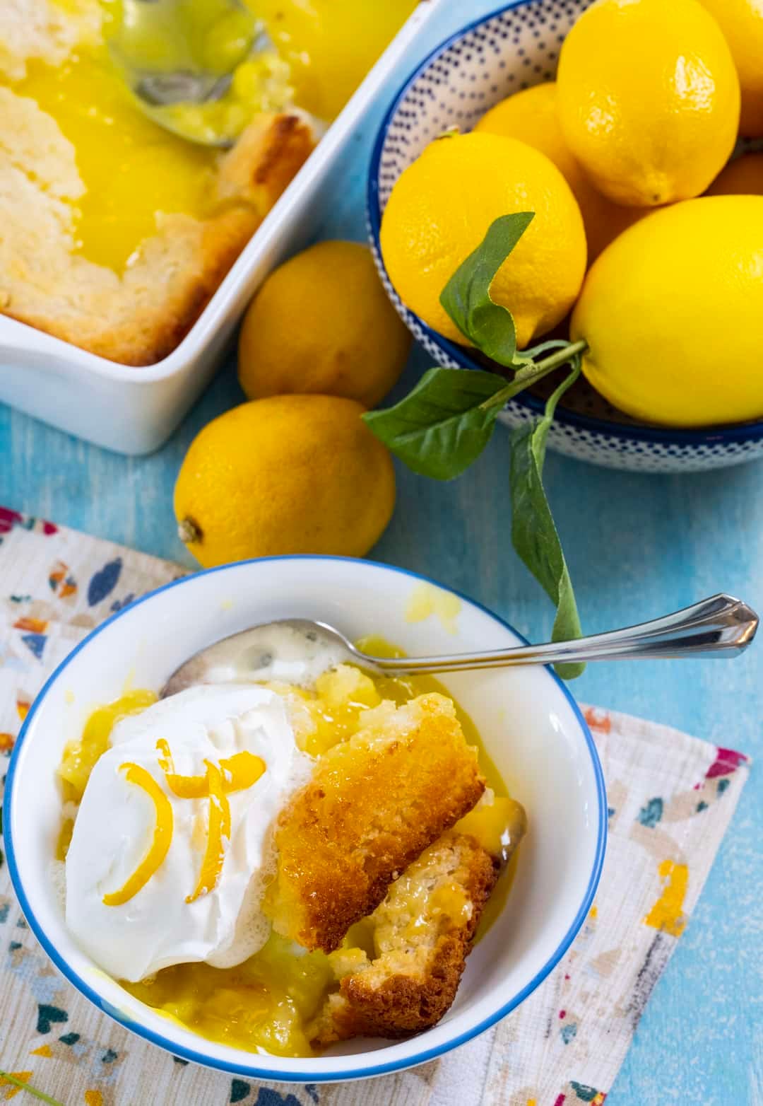 Lemon Cobbler topped with whipped cream in a bowl.