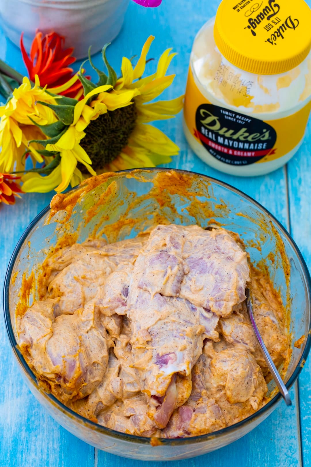 Raw chicken in a bowl with marinade.