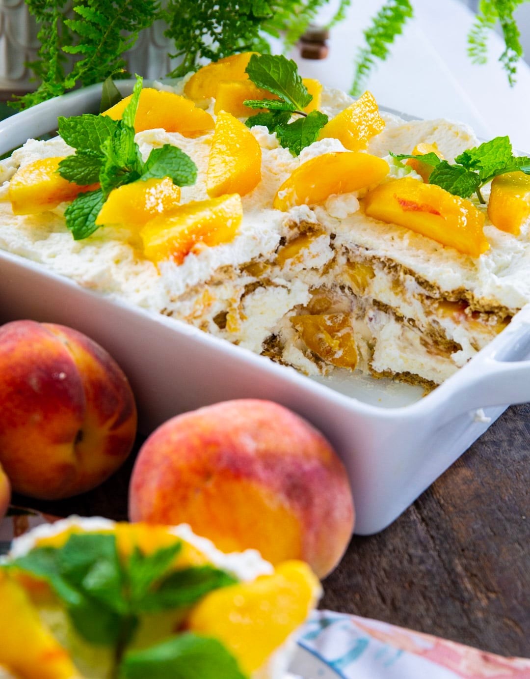 Peach Icebox Cake topped with fresh peach slices and mint sprigs.
