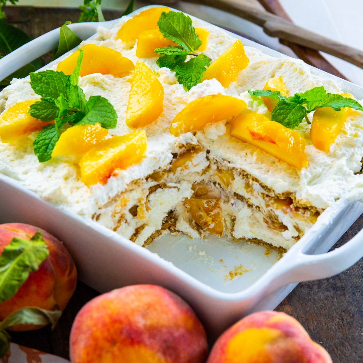 Peach Icebox Cake in a baking dish with slice removed.