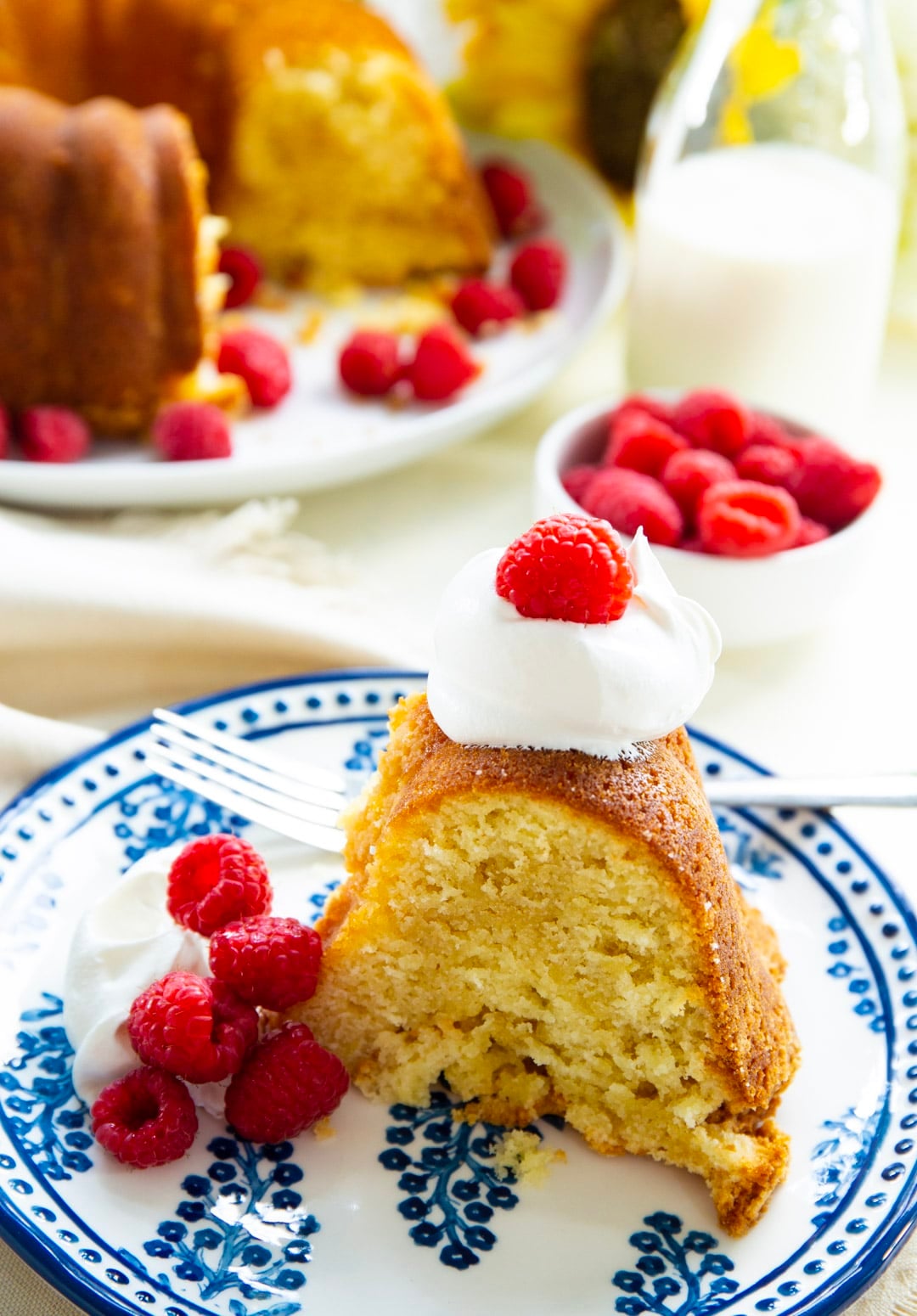 Slice of Buttermilk Pound Cake topped with whipped cream.