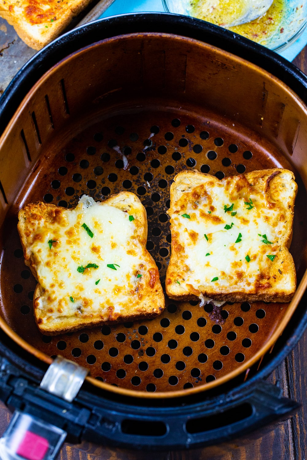 Two slices of Texas Toast in air fryer basket.