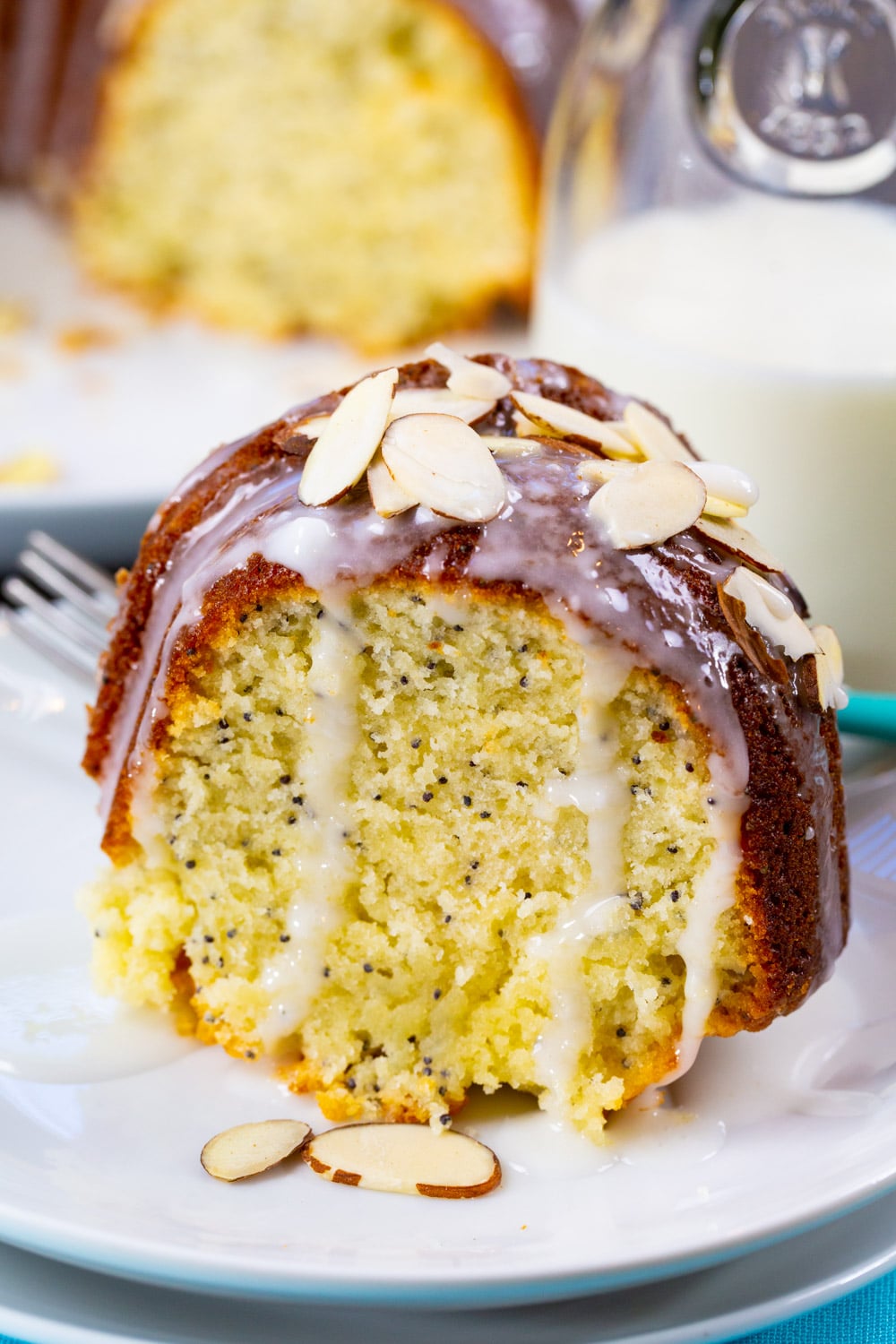 Slice of Almond Poppy Seed Pound Cake with glaze dripping down.