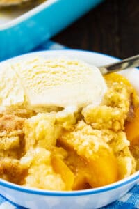 Anytime Peach Cobbler in a bowl with vanilla ice cream