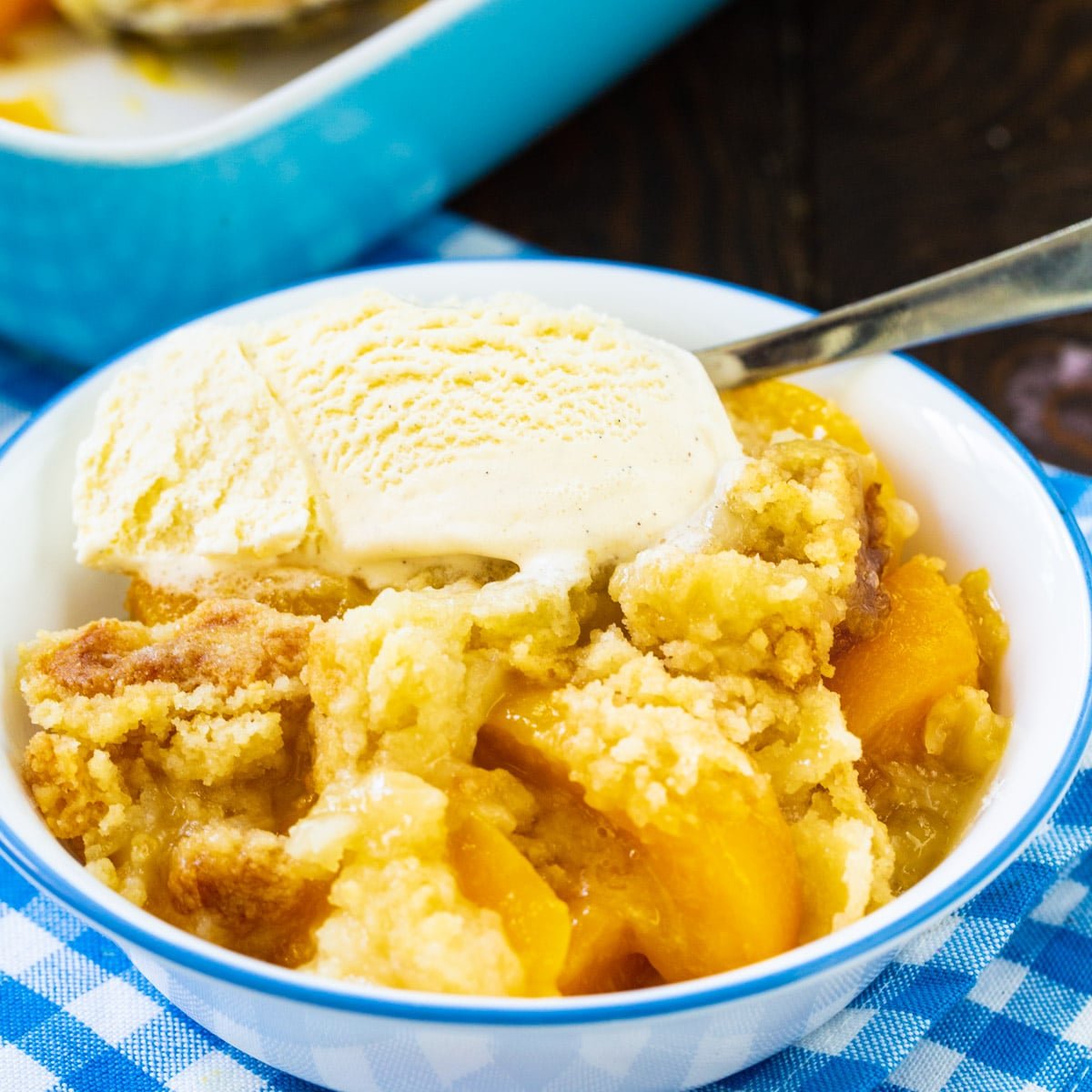 Anytime Peach Cobbler in a bowl with vanilla ice cream