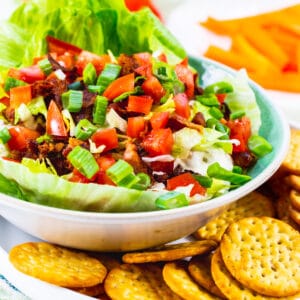 BLT Dip in a bowl surrounded by crackers.