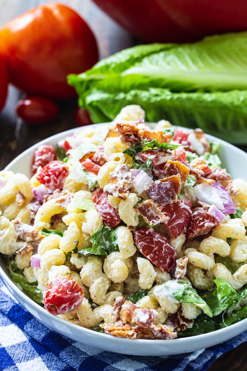 BLT Pasta Salad with tomatoes and lettuce in background.
