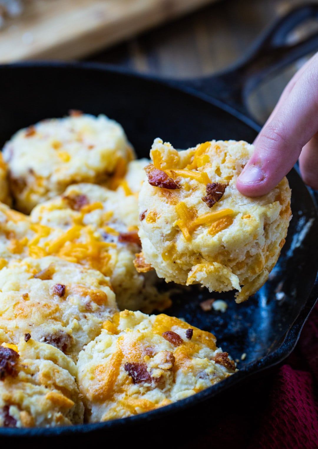 Hand picking up a Bacon Cheddar Biscuit.