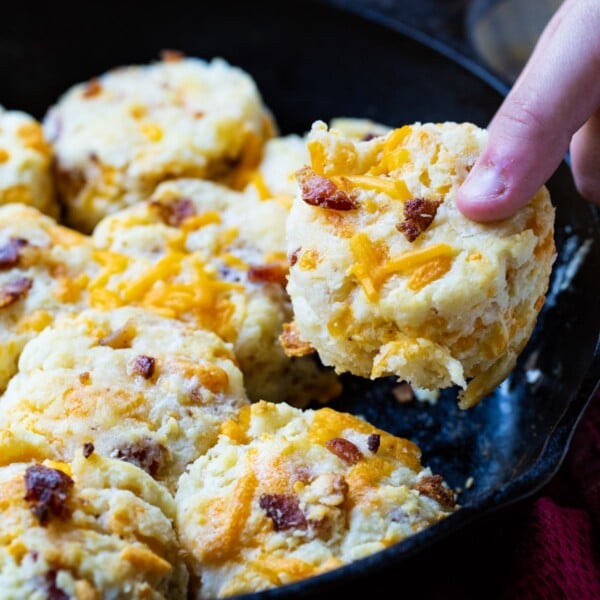 Hand picking up a Bacon Cheddar Biscuit.