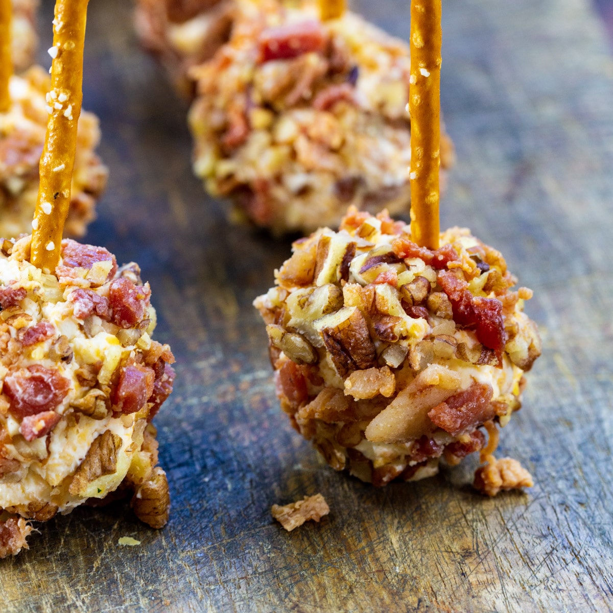 Bacon Cheese Ball Bites with pretzels stuck in them.