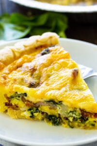 Slice of Bacon Florentine Quiche on a plate.