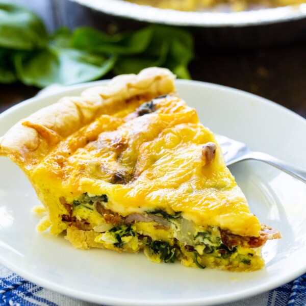 Slice of Bacon Florentine Quiche on a plate.